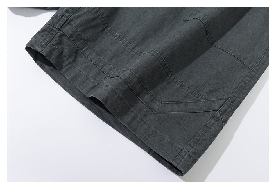Close-up of the dark charcoal pants hem with layered curved stitching and a wide leg opening.