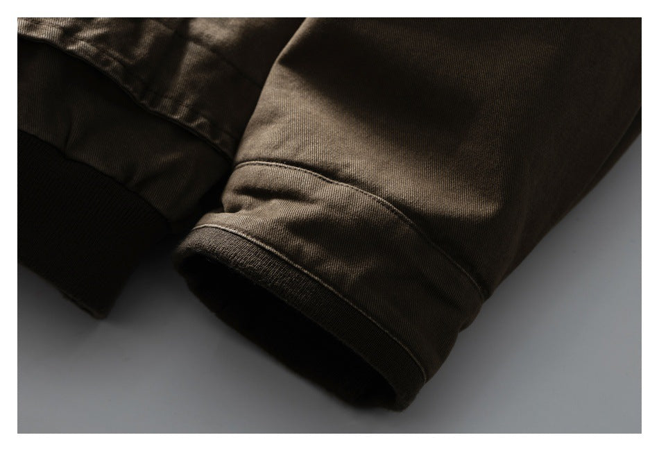 Close-up of the brown jacket sleeve with a dark ribbed cuff and stitched seam.