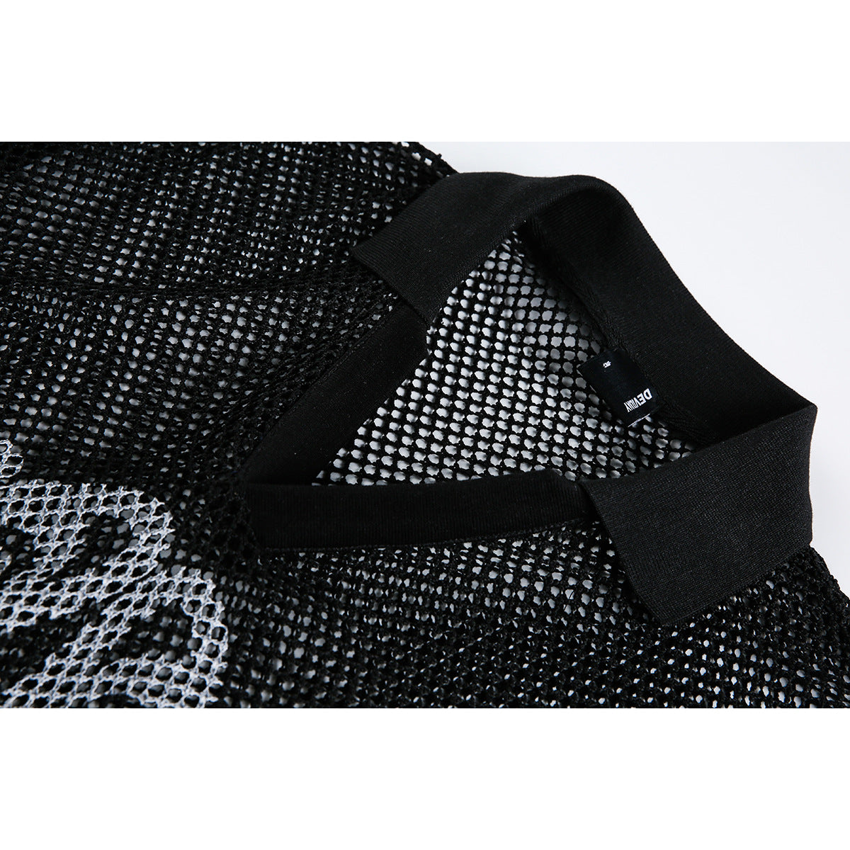 Close-up of a black open-knit garment showing a wide ribbed neckline and a small woven label.