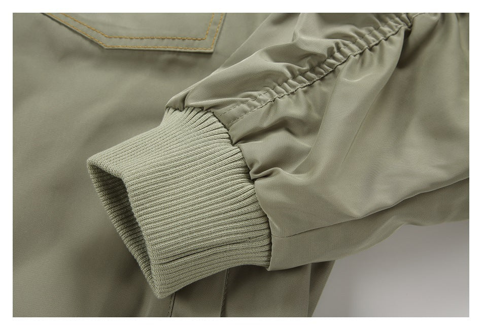 Close-up of the olive jacket’s ribbed cuff, gathered sleeve and stitched pocket edge.