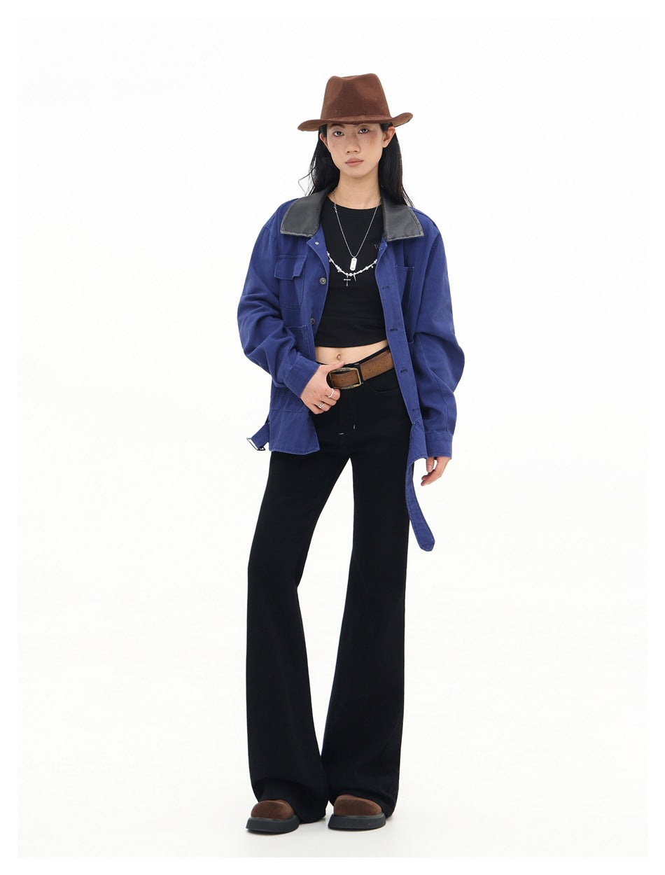 Model wearing a blue button-front jacket with a black collar, black flared trousers, and a brown hat.