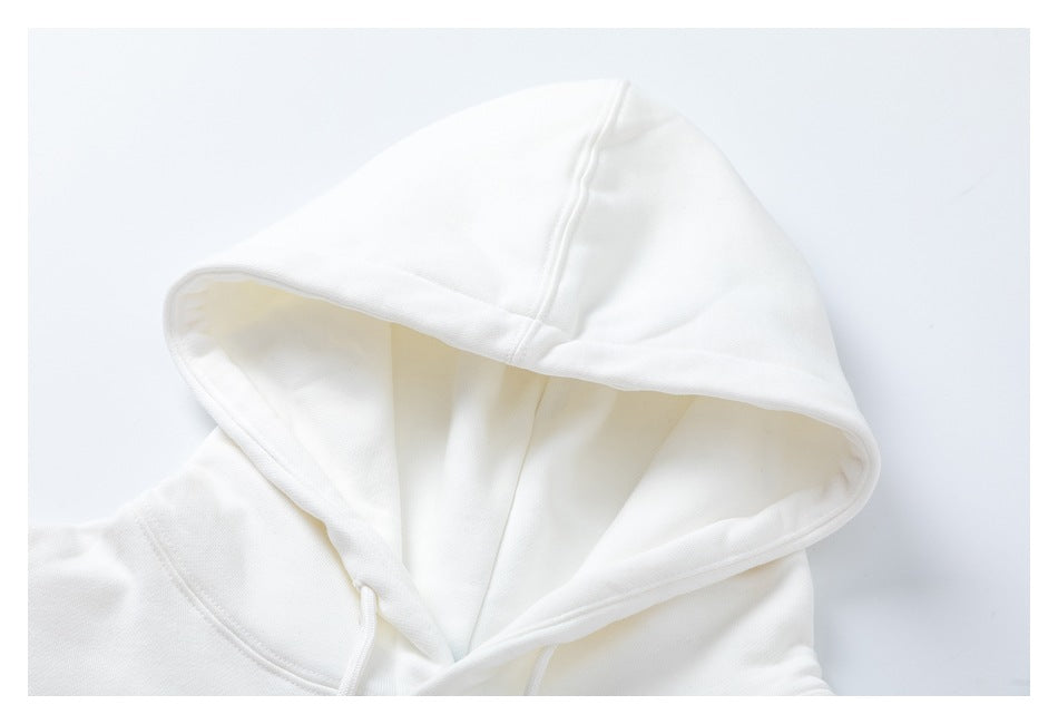 Close-up of the white hoodie's hood, showing its panel seams and stitched edge.