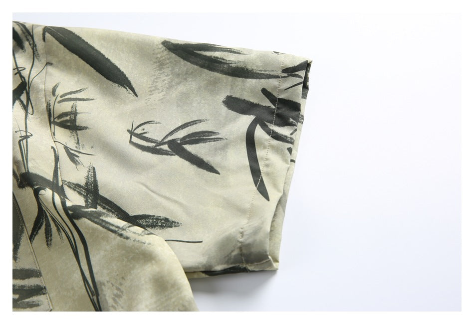 Close-up of a short sleeve edge on a beige shirt with dark bamboo brushstroke print.