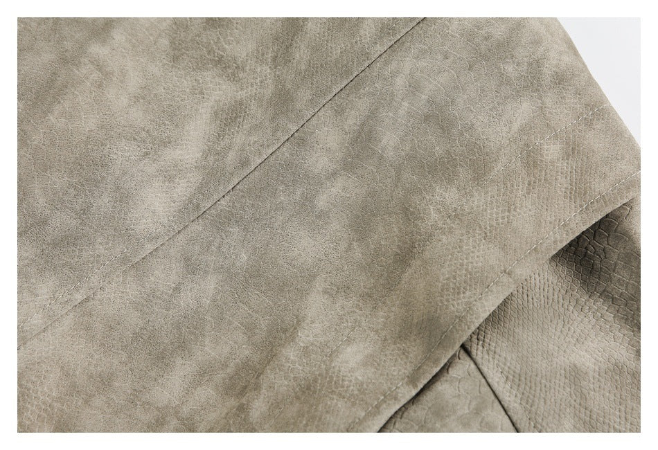 Close-up of taupe jacket panels with contrasting mottled and reptile-like textures and visible stitching.