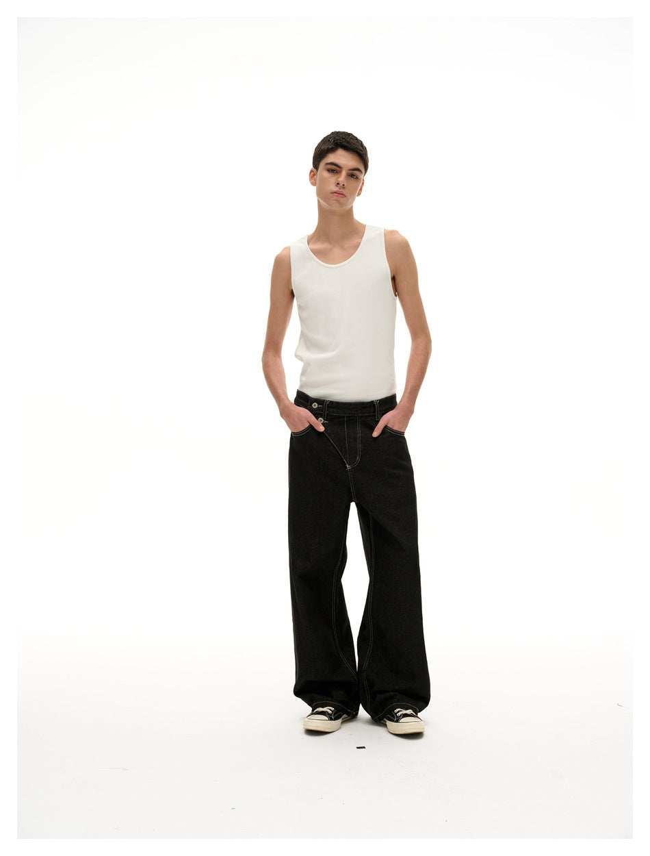 Model wearing black wide-leg jeans with hands in pockets and a white tank top, full-length view