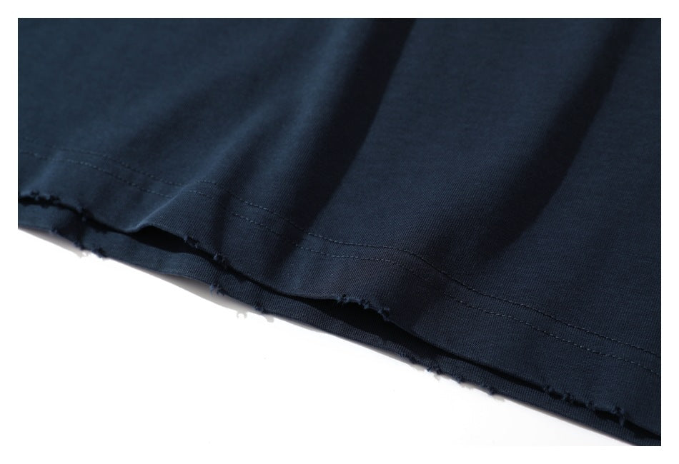 Close-up of the double-stitched, lightly frayed hem of a dark navy shirt.