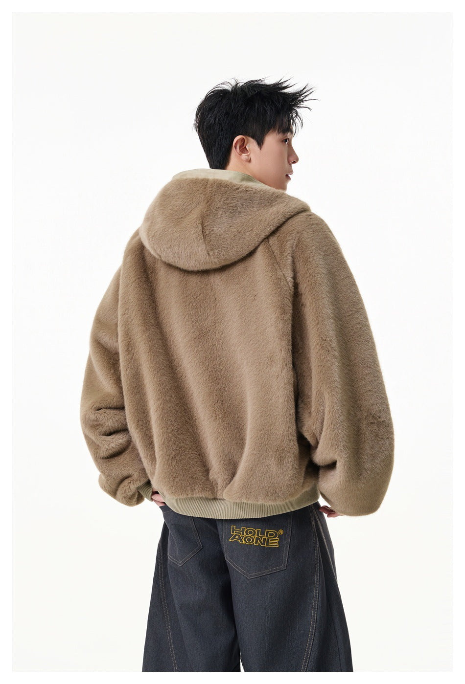 Rear three-quarter view of a model wearing a taupe plush hooded jacket with ribbed trim.