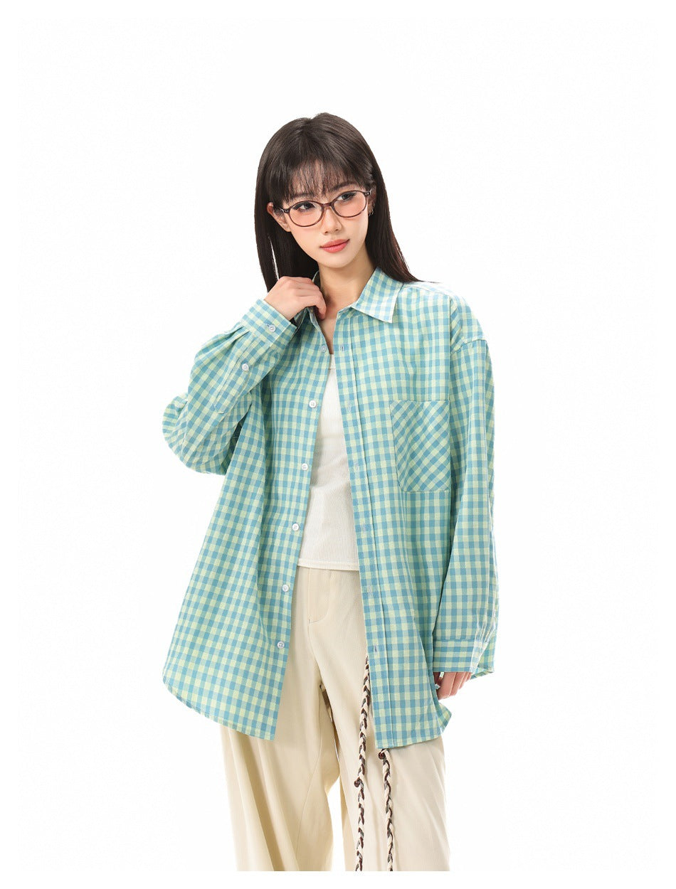 Closer front view of a model wearing an oversized teal and pale yellow gingham shirt with a chest pocket.