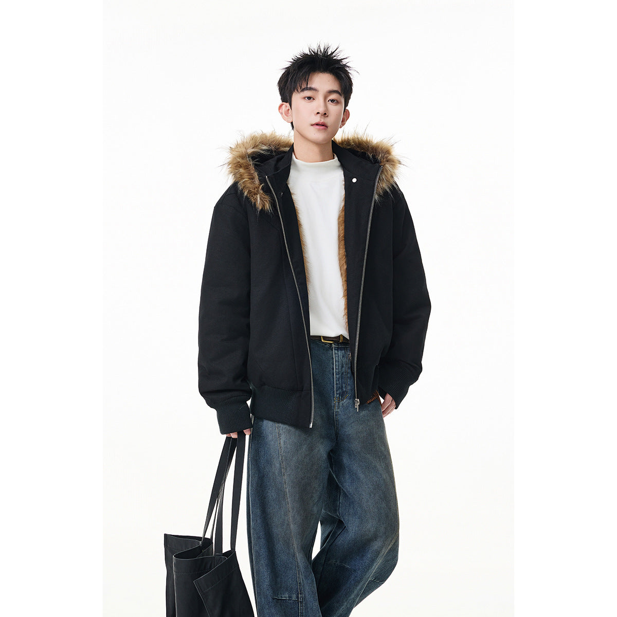 Front view of a model wearing a black zip-front hooded jacket with brown faux-fur trim and ribbed cuffs and hem.