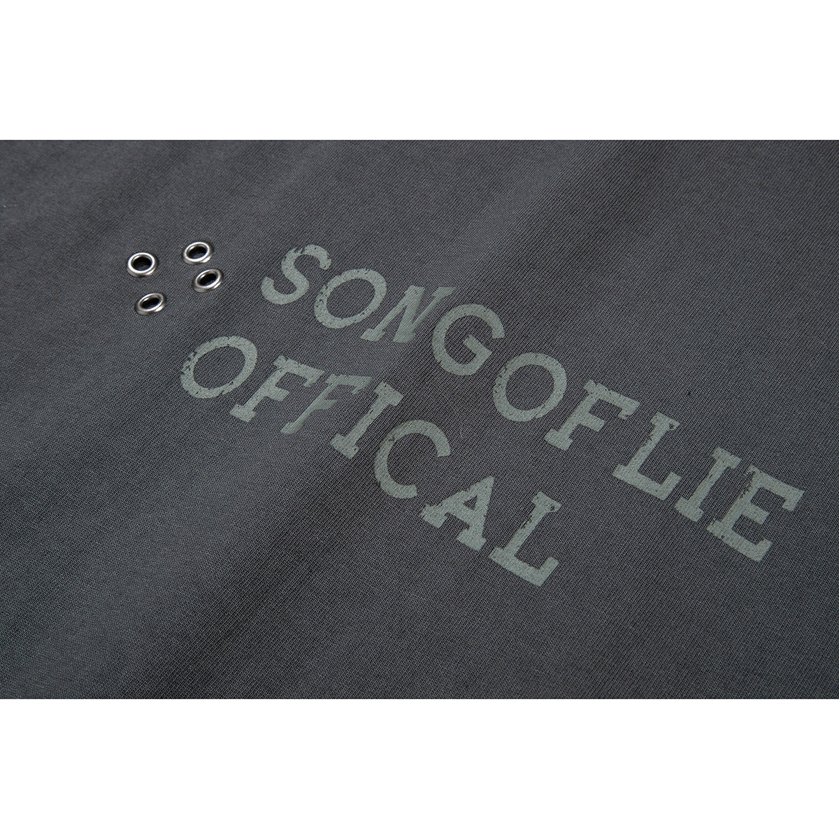 Close-up of charcoal fabric with a faded gray English text graphic and four metal eyelets.
