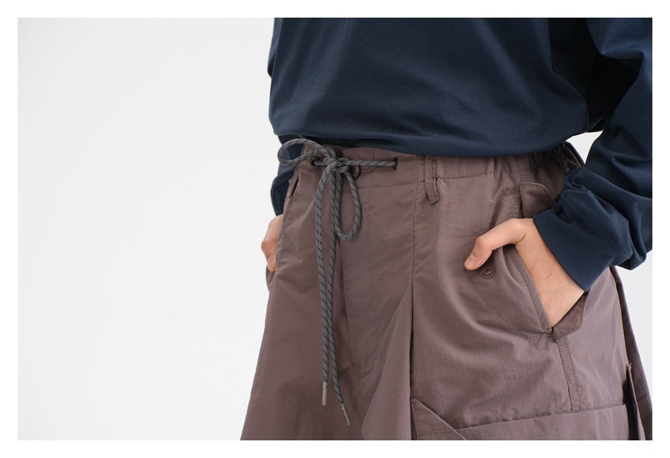 Close-up of mauve shorts showing the elastic waist, drawstring, belt loops, and front pockets.