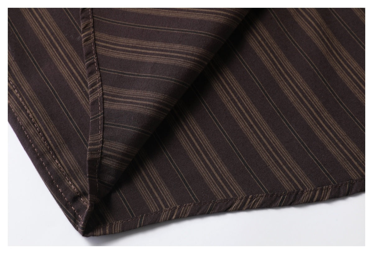 Close-up of dark brown fabric with fine tan stripes and a stitched folded seam.