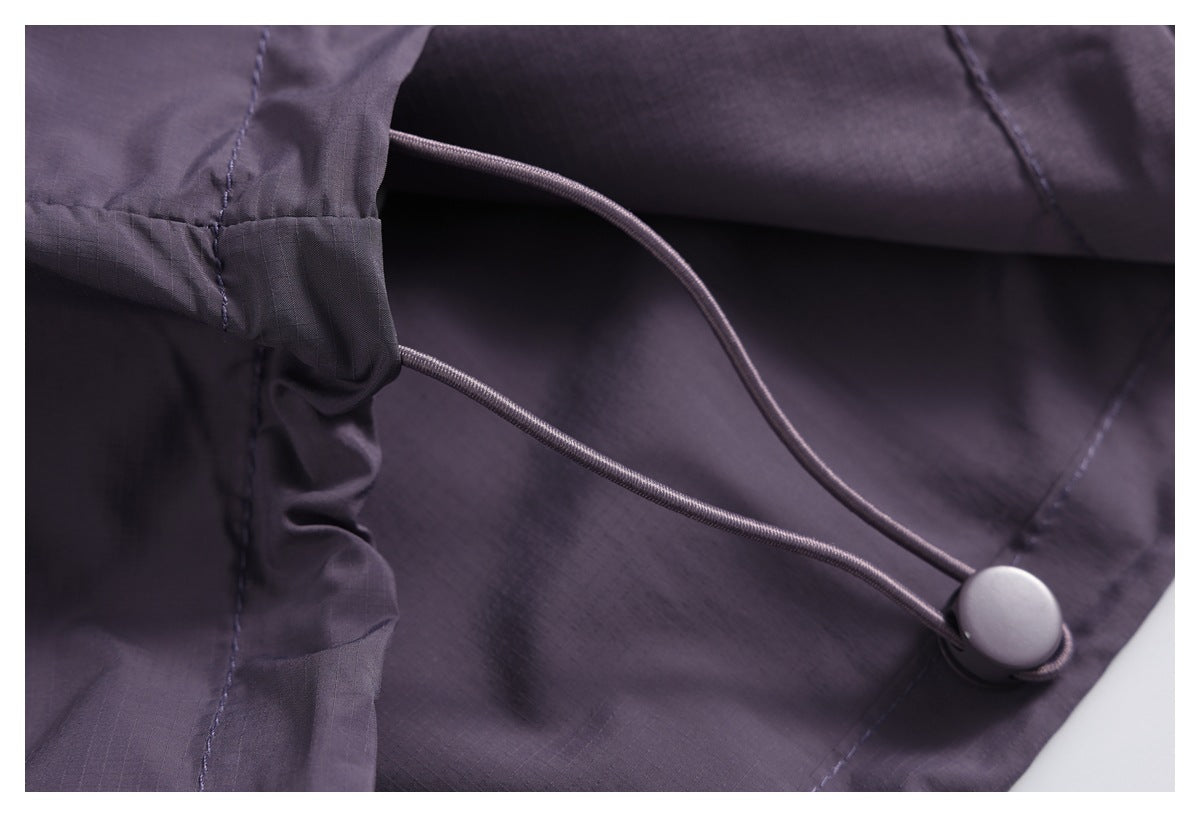 Close-up of a dark purple jacket's adjustable elastic drawcord and toggle.