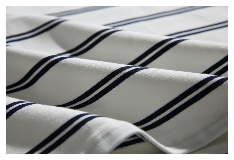 Close-up of softly folded white fabric with parallel navy stripes.