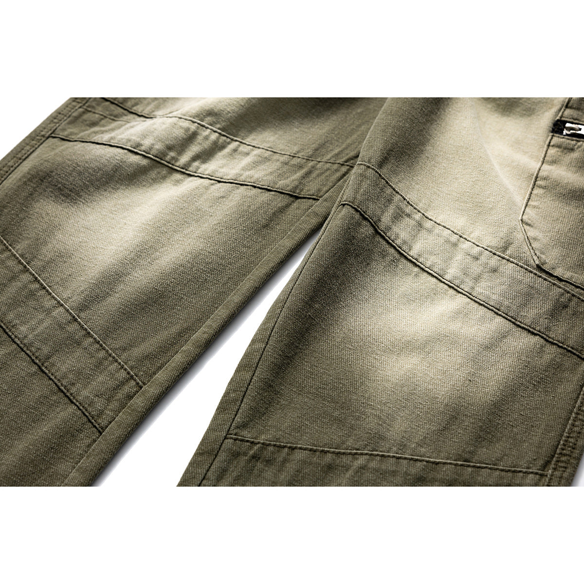 Close-up of olive trouser legs showing contrast fading and angular stitched panels.