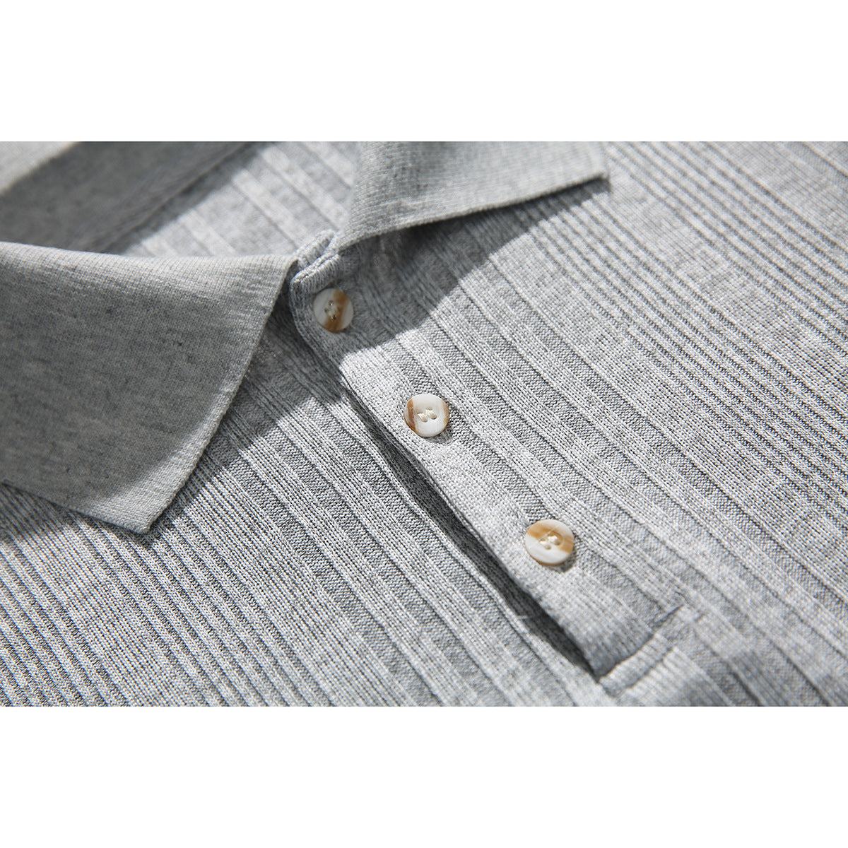 Close-up of a light gray ribbed polo shirt collar and three-button placket.