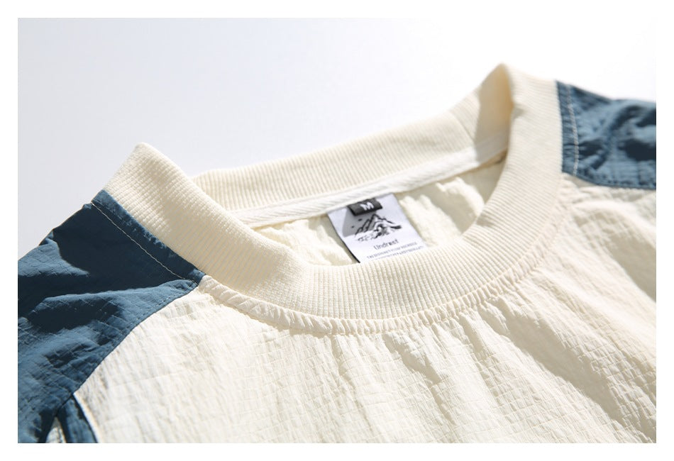 Close-up of the cream ribbed collar and sewn-in neck label on the color-block shirt.