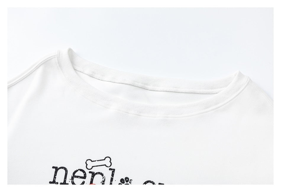 Close-up of a white sweatshirt's ribbed crew neck and upper chest, with part of a black graphic visible.