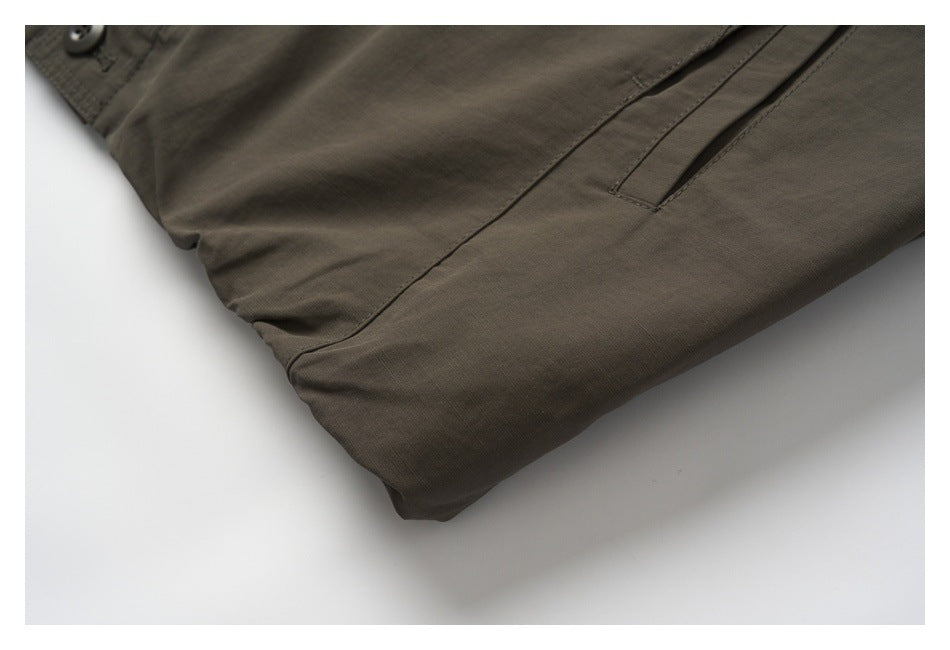 Close-up of the brown jacket's lower front seam and narrow angled pocket opening.