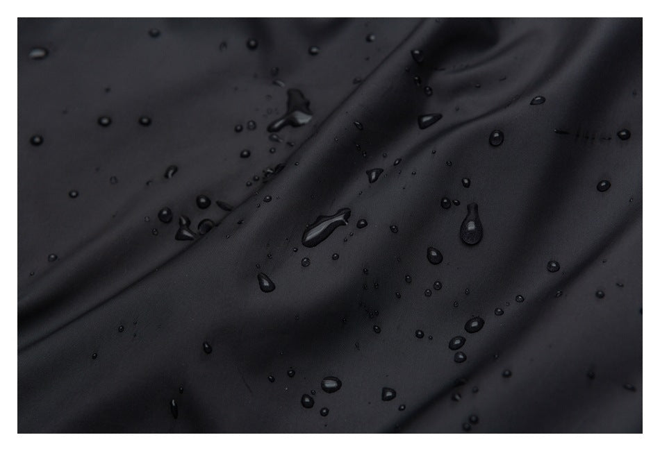 Close-up of black fabric with water droplets beading on its surface.