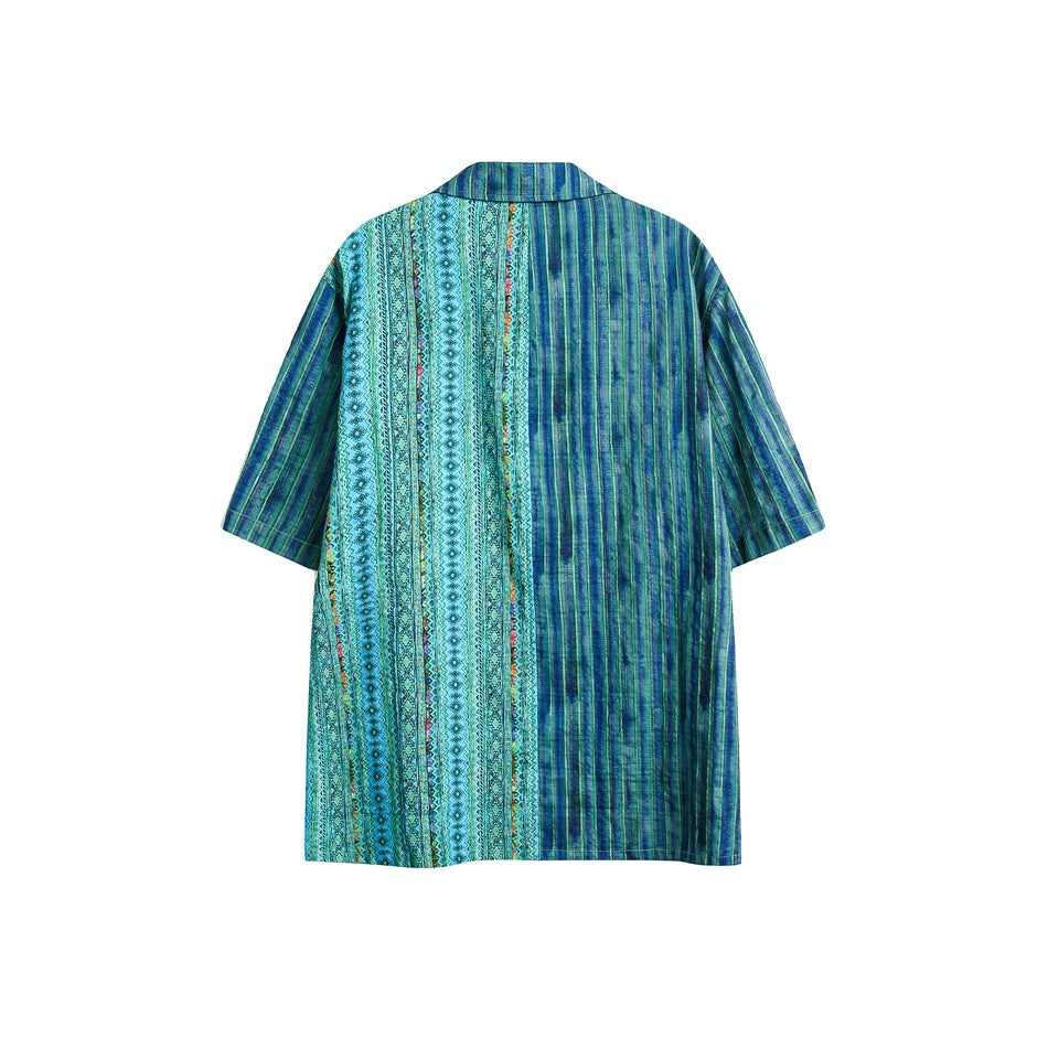 Back view of a short-sleeve collared shirt with blue-green stripes and geometric patterned panels.