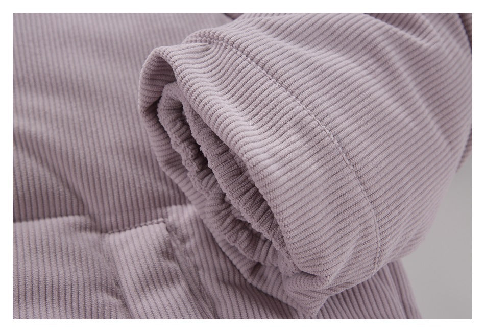 Close-up of a pale mauve ribbed corduroy sleeve cuff and seam.