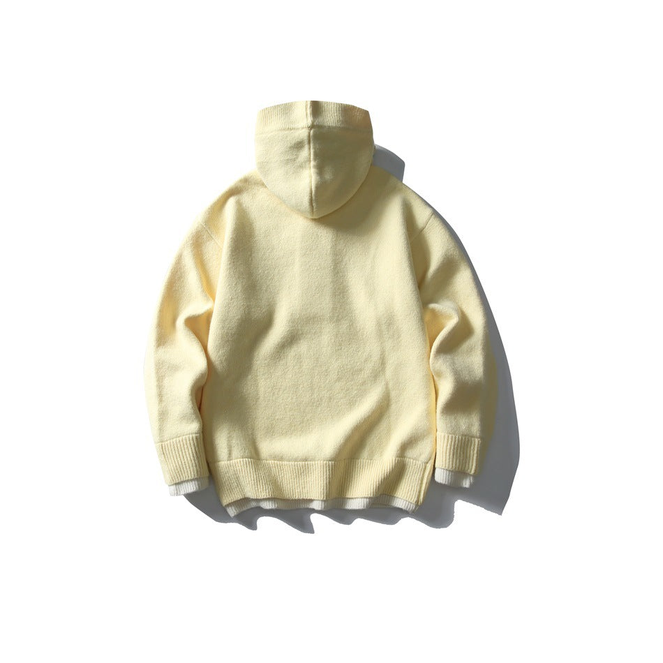 Back view of a pale yellow hooded knit top with ribbed cuffs and hem and a light underlayer.
