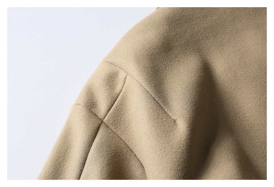 Close-up of a beige coat sleeve with a visible curved seam.