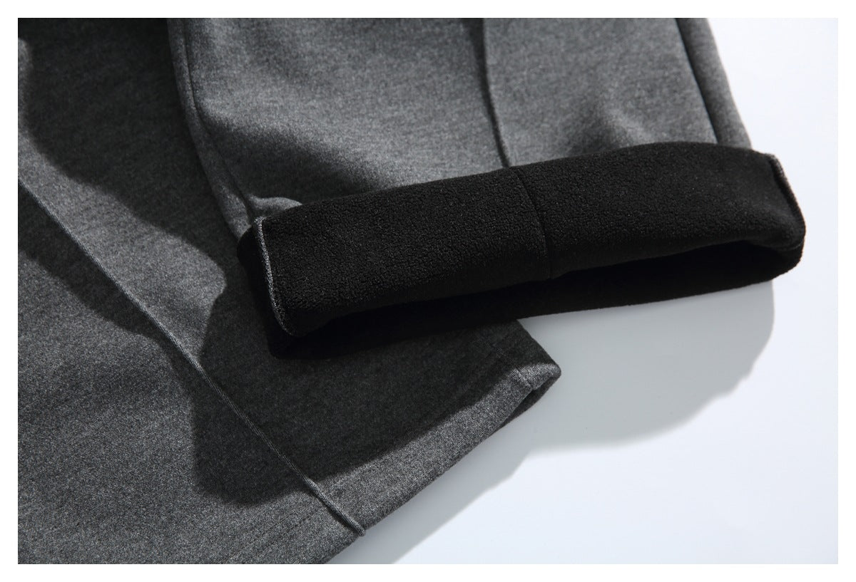 Close-up of a charcoal gray pant leg hem folded back to reveal a black inner lining.