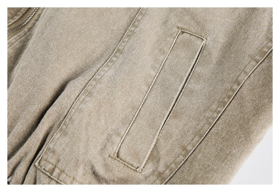Close-up of a rectangular stitched pocket on beige-tan garment fabric.