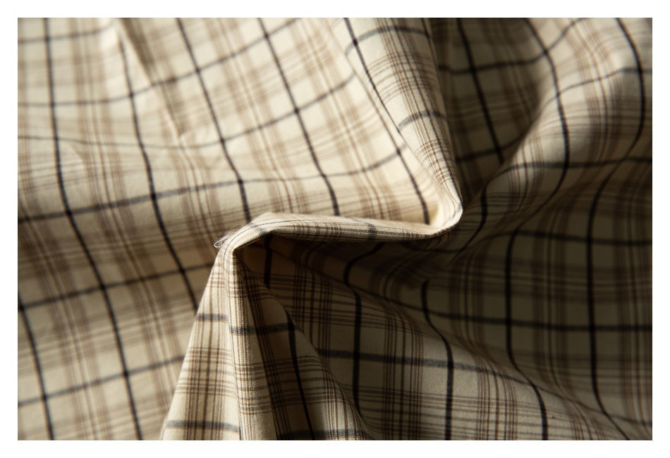 Close-up of beige and brown plaid fabric draped into soft folds.