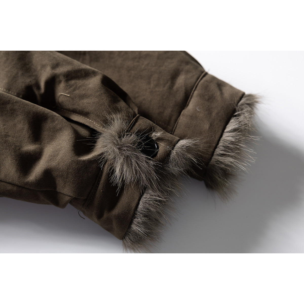 Close-up of a dark brown jacket cuff with fur trim, a button tab, and visible stitching.