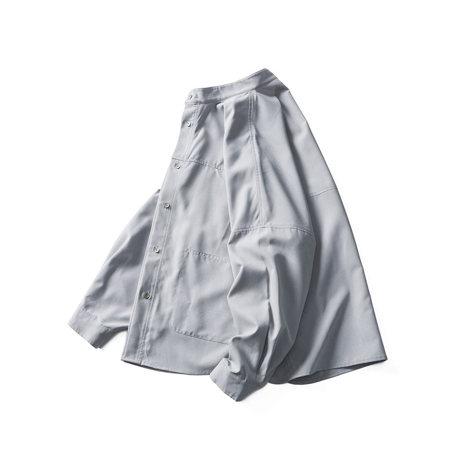 Angled front view of a light gray button-front shirt with a stand collar, long sleeves, and chest pocket.