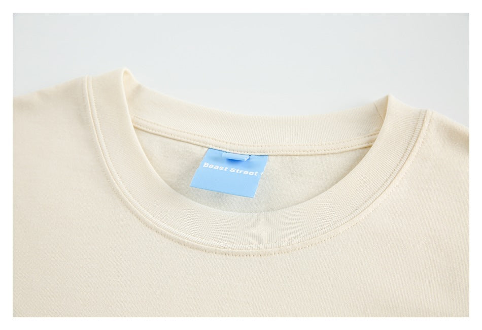 Close-up of a cream shirt's ribbed crew neck and blue inner label.