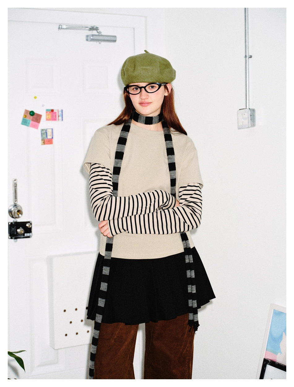 Model wearing the Apricot layered striped-sleeve top with a green beret, striped scarf, black pleated skirt and brown pants
