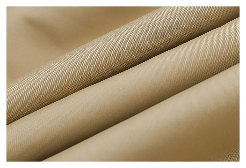 Close-up of beige fabric folded into diagonal layers, showing its fine surface texture.