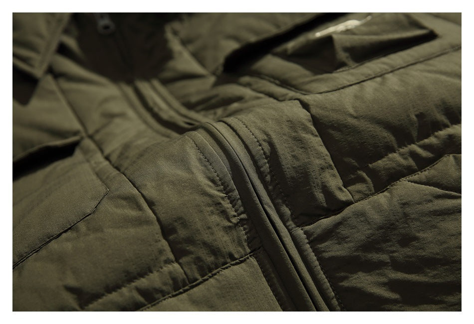 Close-up of an olive padded jacket showing the front zipper, quilted panels, and pocket seams.