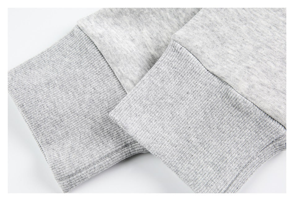 Close-up of light gray jacket sleeves with wide ribbed cuffs and seam stitching.