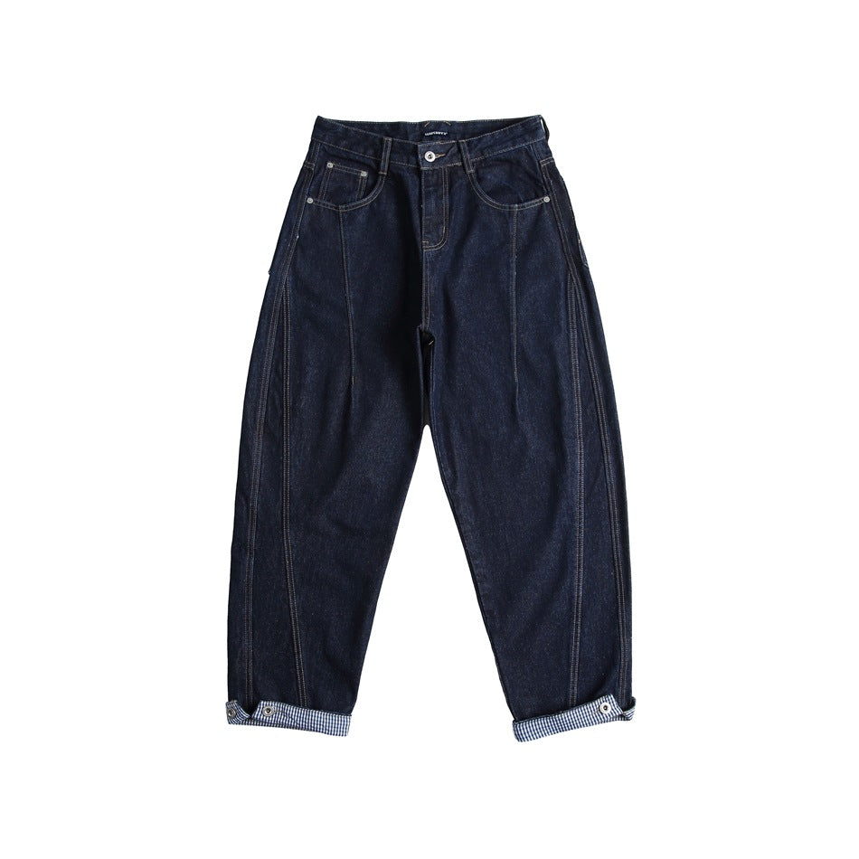 Front view of dark navy wide-leg jeans with tan topstitching, vertical leg seams and rolled gingham-lined cuffs