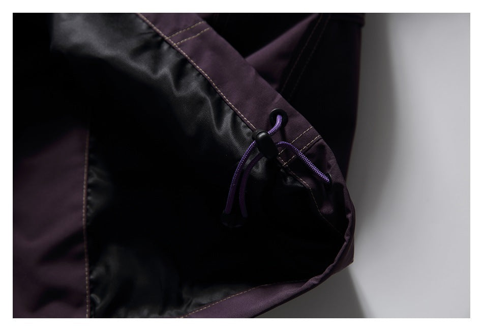 Close-up of a garment's black lining, plum trim, and purple drawcord toggle.