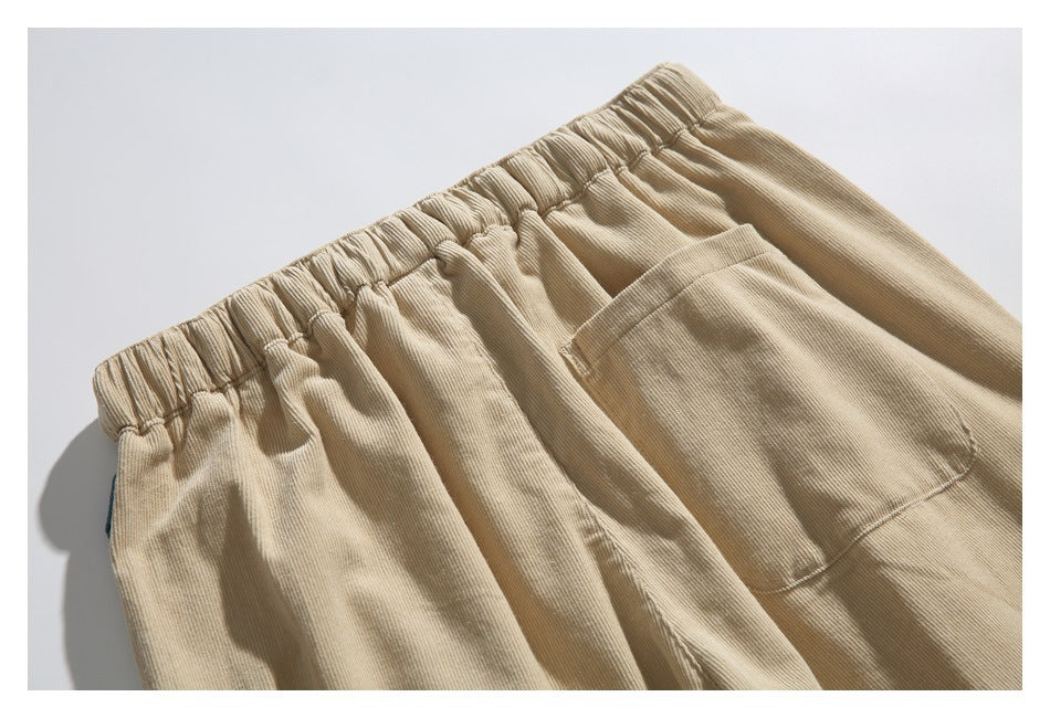 Close-up of beige pants showing the gathered elastic waistband and a large front pocket.