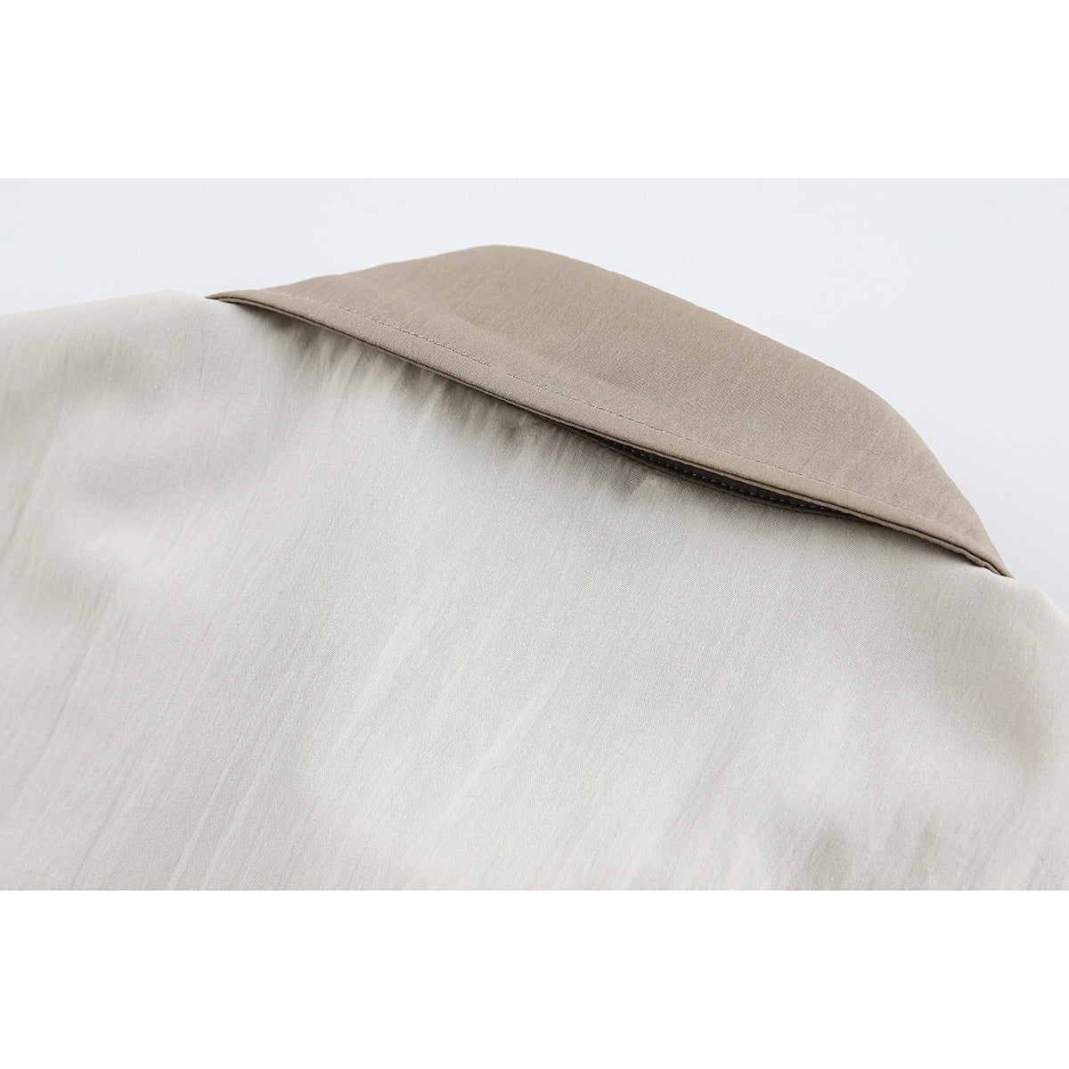 Close-up of the back collar and yoke seam on a light beige shirt.