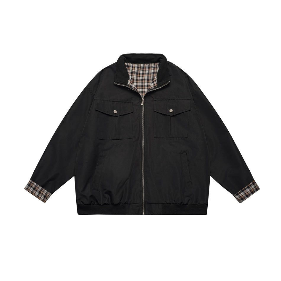 Black zip-front jacket with stand collar, flap chest pockets and brown plaid lining at collar and cuffs