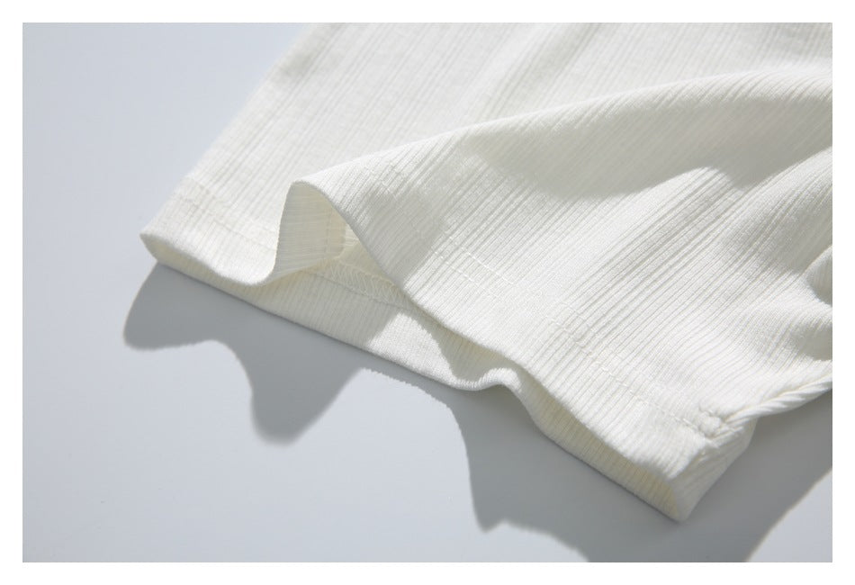 Close-up of the white ribbed short-sleeve cuff and stitched hem.