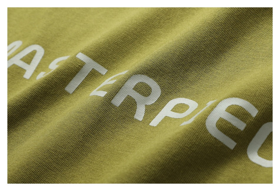 Angled close-up of partial white lettering printed on olive fabric, with the cloth folded into a ridge.
