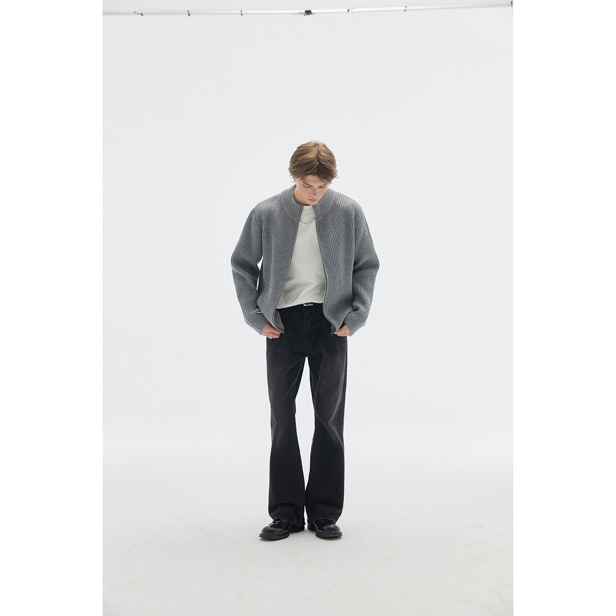 Model wearing a gray ribbed cardigan with an open front, styled with a white shirt and black trousers.