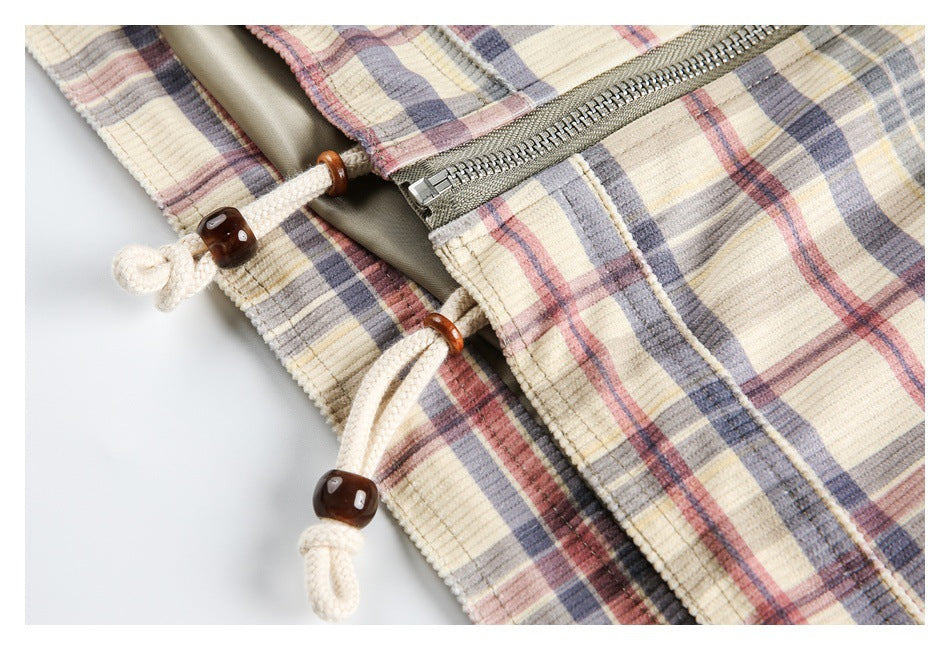 Close-up of the plaid jacket's metal zipper and cream drawstrings with dark wood-tone toggles.