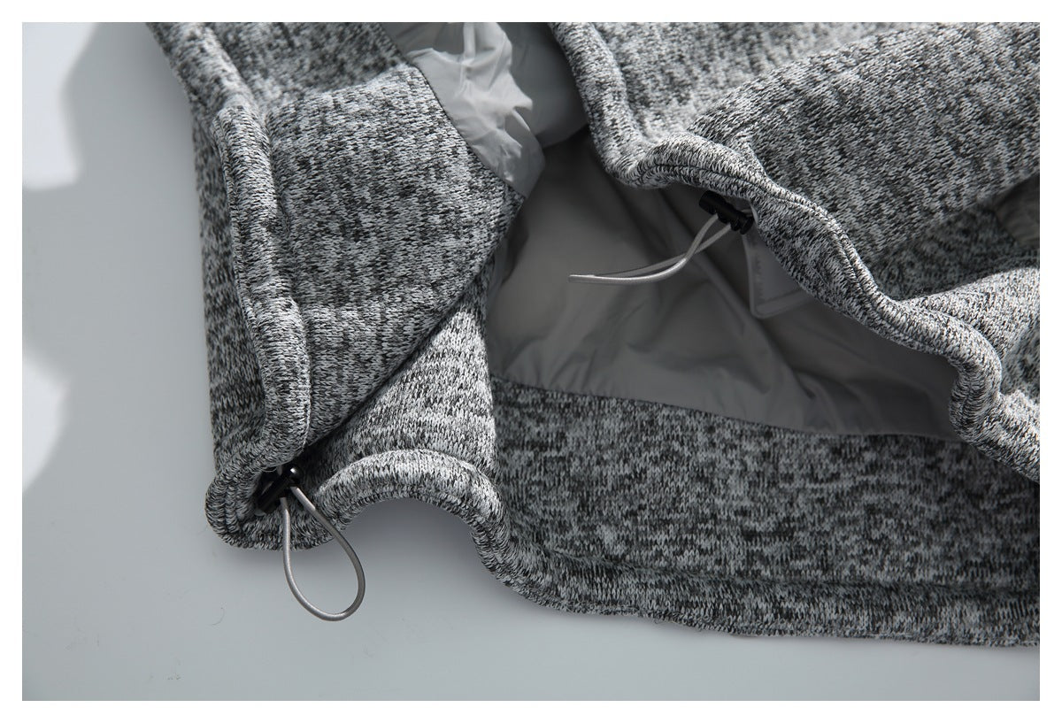 Close-up of a gray-and-black marled garment edge with a light gray lining and adjustable drawcord.