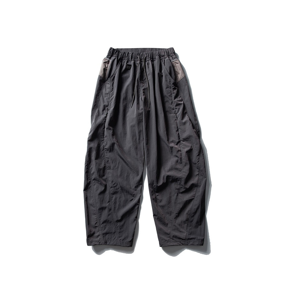 Dark gray wide-leg drawstring pants with taupe contrast side panels, flat lay front view