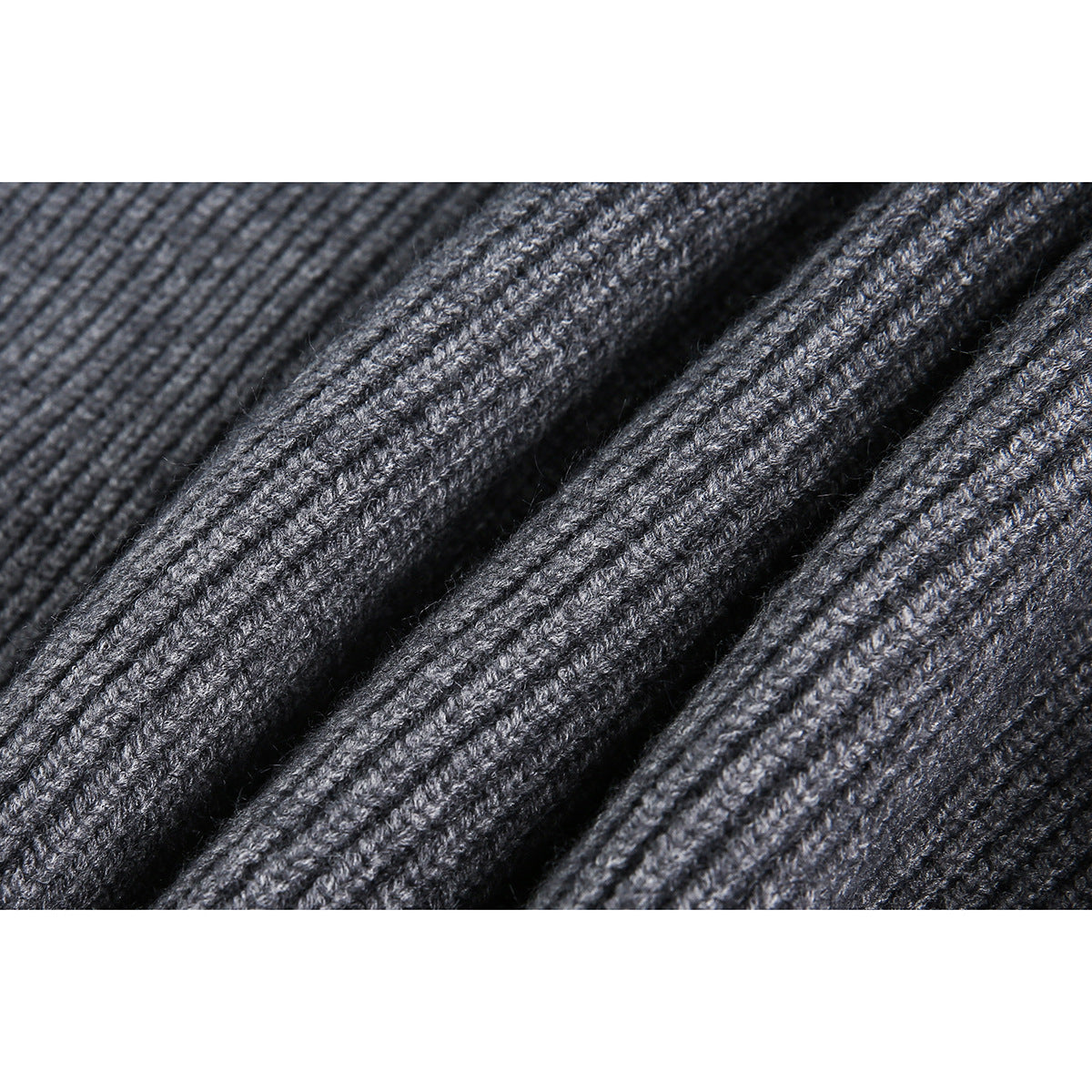 Macro view of the textured gray rib-knit sweater fabric.